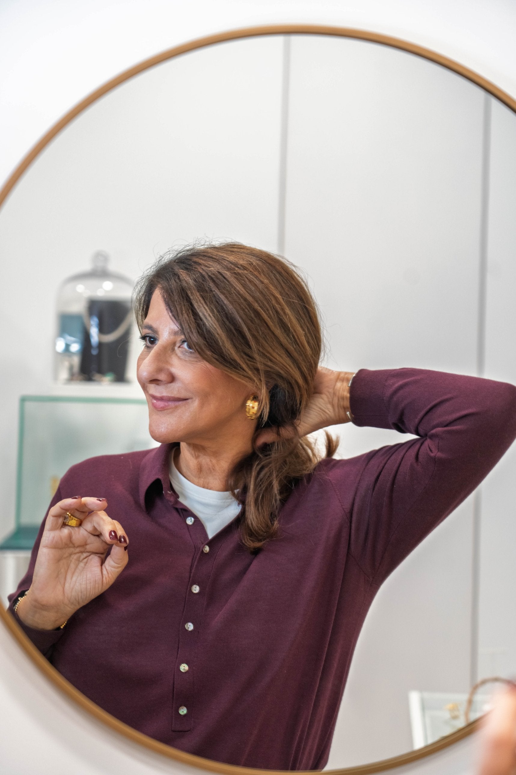 Julieta Faria ao espelho com brincos e anel JF Jóias